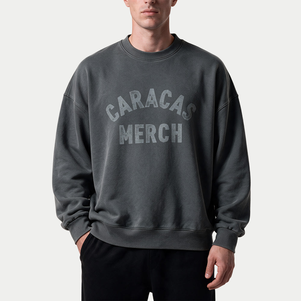 Male model wearing the gray oversized vintage wash crewneck by Caracas Merch, front view